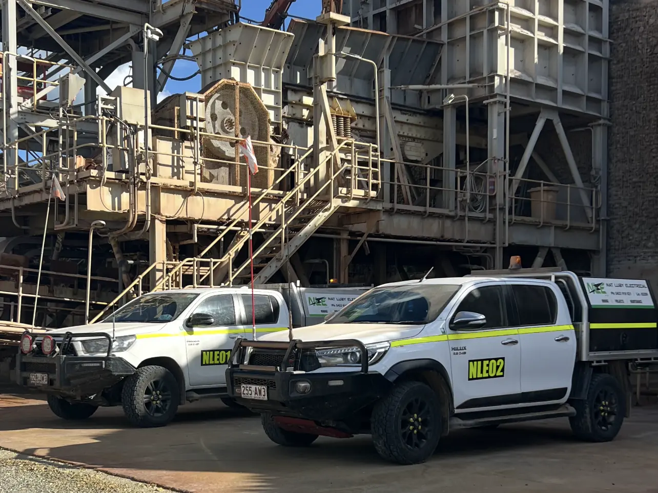 Both Nat Luby Electrical utes parked at a crushing plant