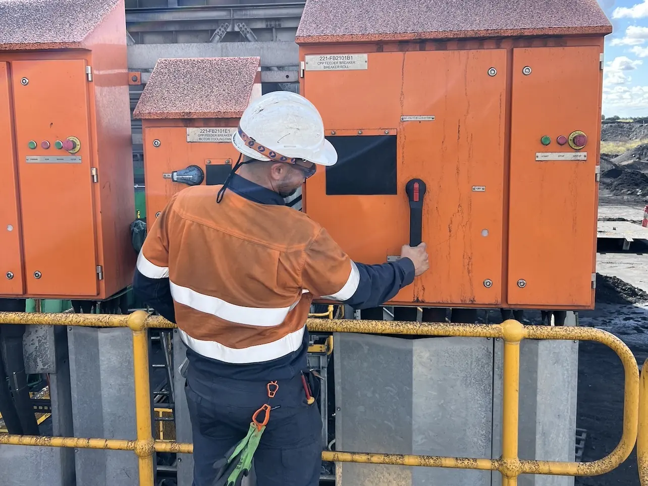 Electrician operating an isolator on a coal plant feeder breaker switchboard