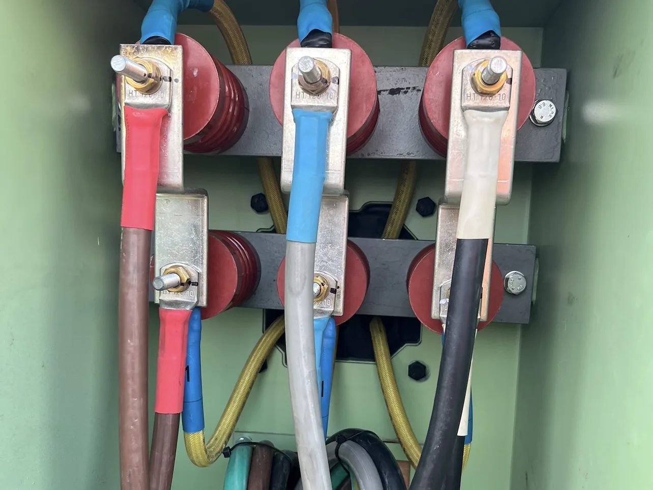 Open high voltage switchgear cabinet with labelled terminals and cabling