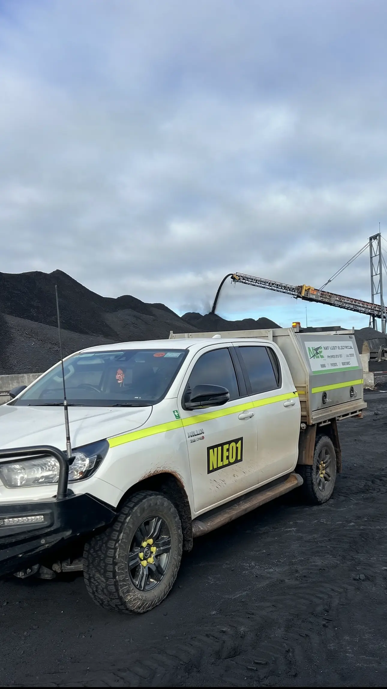 Two Nat Luby Electrical utes parked at a coal crushing plant on a Queensland mine site